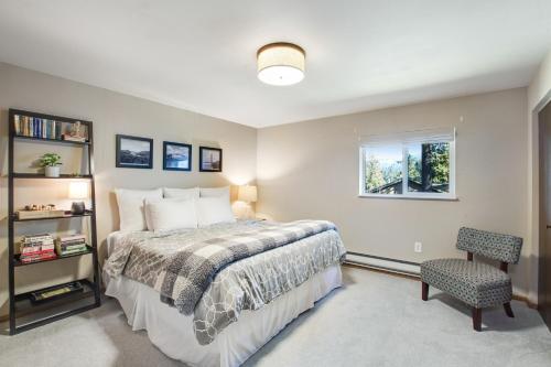 a bedroom with a bed and a window and a chair at The Treehouse in Bellingham