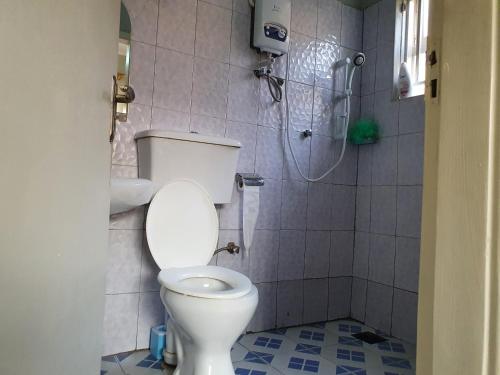 La salle de bains est pourvue d'une douche et de toilettes. dans l'établissement Dees shared home away from home, à Entebbe