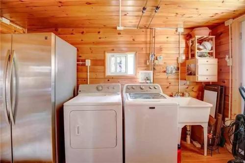 a kitchen with a refrigerator and a washer and dryer at Riverside Cabin with Private Fishing Access! in Pulaski