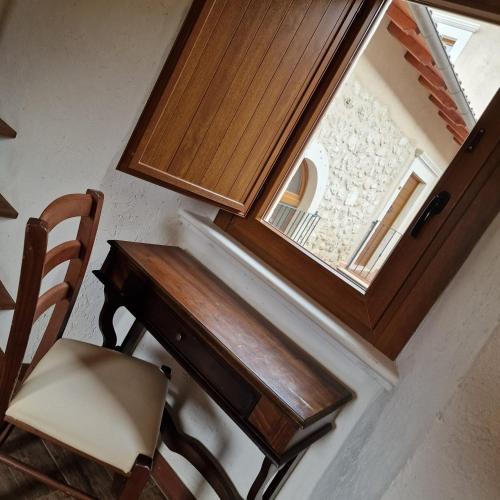 a wooden desk and a chair next to a window at Il pozzo dei desideri in Castelnuovo
