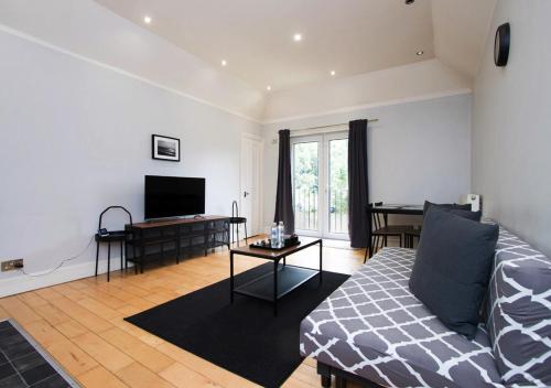 a living room with a couch and a flat screen tv at Westciti Caroco Aparthotel in Croydon