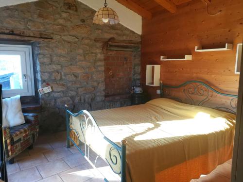 een slaapkamer met een bed en een stenen muur bij Ca del Vecchio in Ponte Nizza