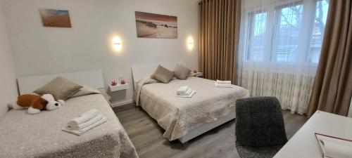 a bedroom with two beds and a teddy bear sitting between them at Nadia&V in Marghera