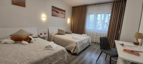 een hotelkamer met twee bedden en een teddybeer erop bij Nadia&V in Marghera