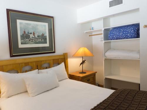 een slaapkamer met een bed met witte lakens en een lamp bij 3132 Aspen Grove in Truckee