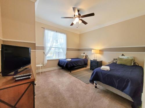 a bedroom with two beds and a flat screen tv at Spacious Vista Cay Condo near Universal Studios in Orlando