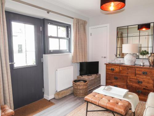 Sala de estar con puerta negra y TV en The Pottery, en Newport