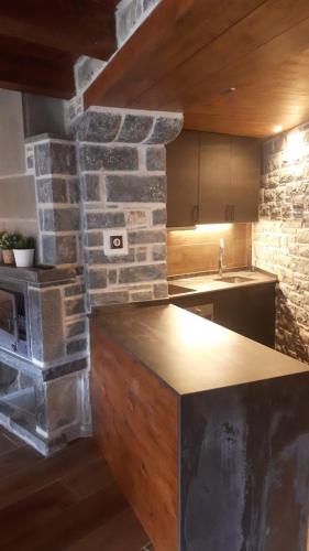 a kitchen with a stone wall and a counter top at Hotel Rural El Portón de Murillo in Broto