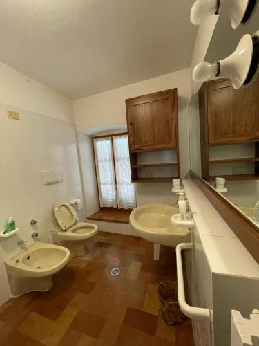 a bathroom with two sinks and a toilet and a sink at Casa Dei Lecci in Foligno