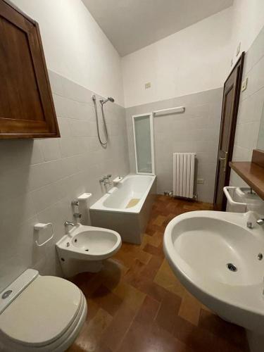 a bathroom with a white toilet and a sink at Casa Dei Lecci in Foligno