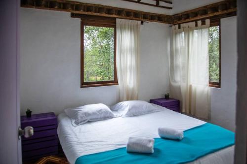 ein Schlafzimmer mit einem Bett mit zwei Handtüchern darauf in der Unterkunft Casa de Campo-Chimenea-Casita en el árbol- WiFi :) in Villa de Leyva