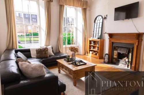 a living room with a couch and a fireplace at Venture Suite in Glasgow