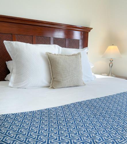 a bed with white pillows and a wooden headboard at Harborside Inn in Newport