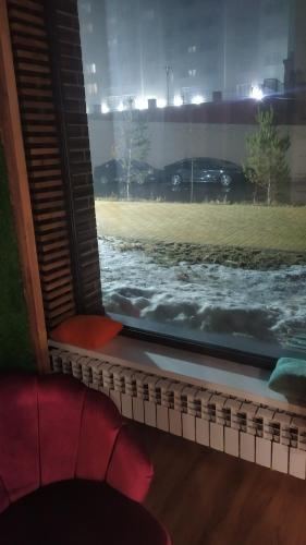 una ventana con vistas a un campo cubierto de nieve en Hostel Caps Home, en Astana
