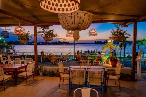 a restaurant with tables and chairs and a view of the water at Hotel Petén Express in Flores