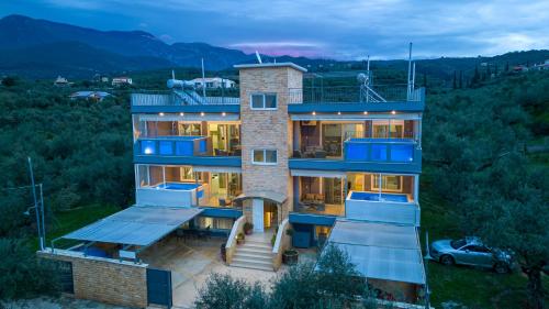 a house with a car parked in front of it at Grand Suites with Private Pools in Kalamata