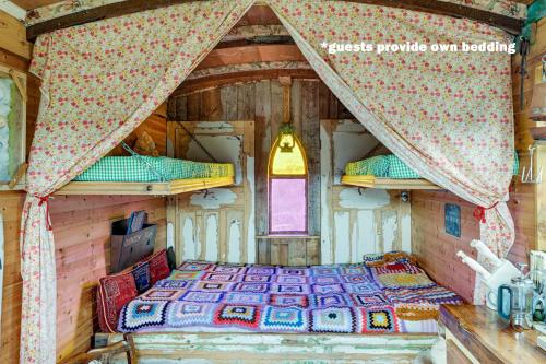ein Schlafzimmer mit einem Bett in einer Holzhütte in der Unterkunft Glamping Wagon - 1 x Double Bed 2 x Single Bed in Scarborough