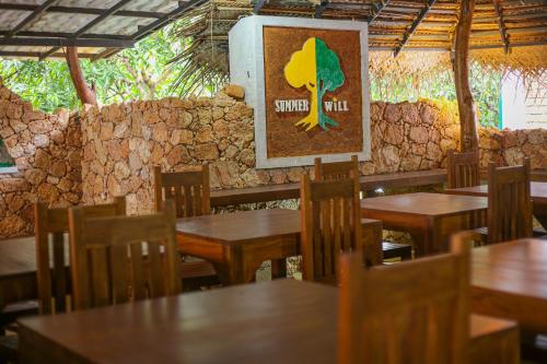 un restaurant avec des tables et des chaises en bois et une photo dans l'établissement Summer Will Resort, 