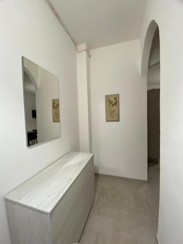 Cette chambre blanche dispose d'un banc et d'un miroir. dans l'établissement SeaView Apartments Caprioli-Palinuro, à Palinuro