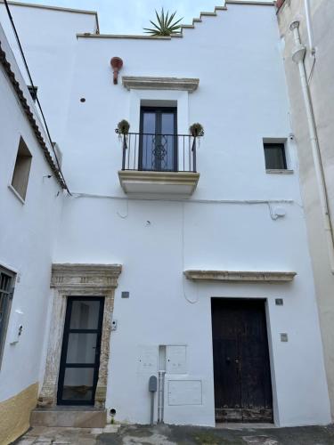 a white building with a balcony and a door at Suite Guagnano Luxury apartment in Nardò