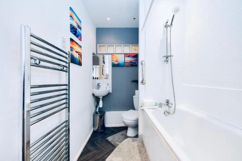 a bathroom with a tub and a toilet and a shower at Impeccable 4-Bed House in Brixton London in London
