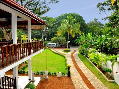 a balcony of a house with a garden at Rockery Villa Ayurveda in Bentota