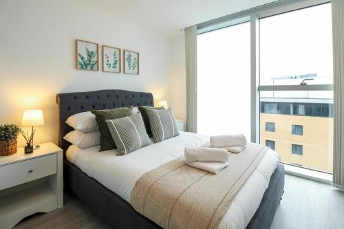 um quarto com uma cama grande e uma janela grande em The Hub by Pay As U Stay em Milton Keynes