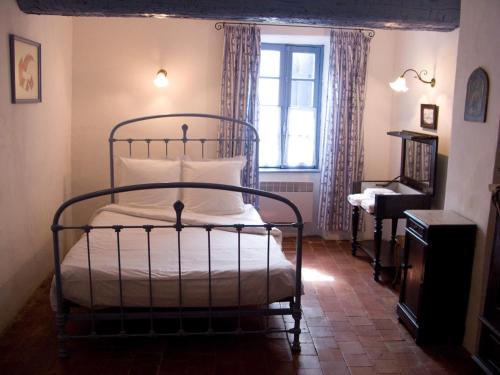 a bedroom with a bed and a window at La Placette - votre maison en pierres authentique in Bizanet