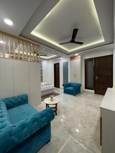 a living room with a blue couch and a table at Maps Inn in Ghaziabad