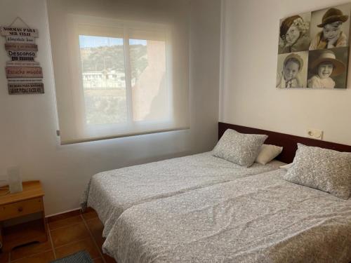 1 dormitorio con cama y ventana en Apartamentos Mar Azul, en Almerimar