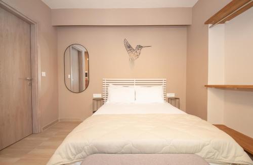 ロードス・タウンにあるNew Town Apartmentsのベッドルーム1室(壁に鳥が1羽付いたベッド1台付)