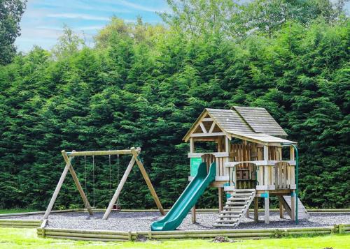 a playground with a slide and a play structure at Paradise Lakeside Lodges in Wheldrake