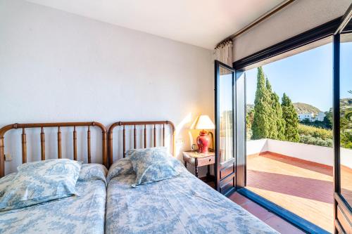 a bedroom with two beds and a balcony at Casa La Cúpula in Agua Amarga