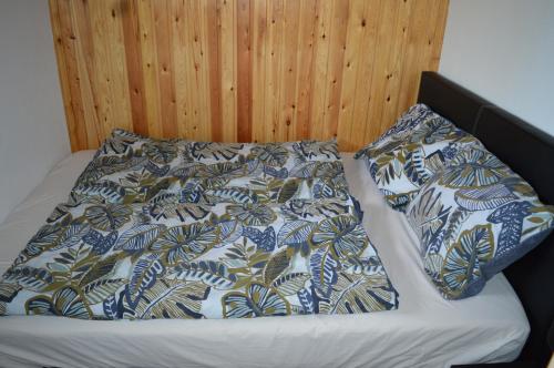 Una cama con dos almohadas encima. en Beaux petits appartements, en La Calamine