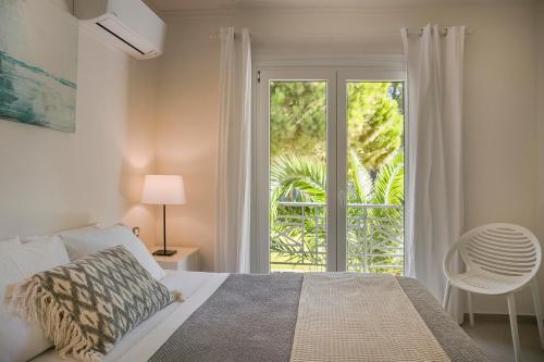a bedroom with a bed and a sliding glass door at MARILIA VILLAS LASSI in Lassi