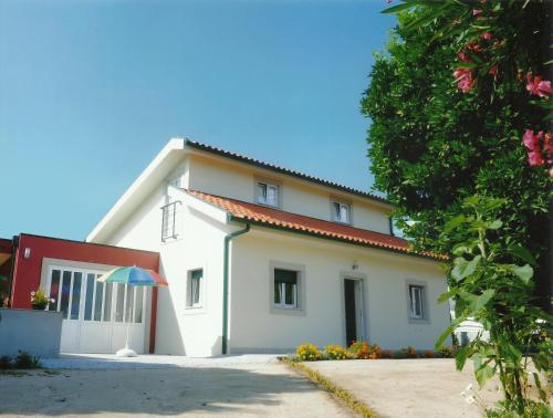 a white house with a red roof at Casa Quelhas in Besteiros