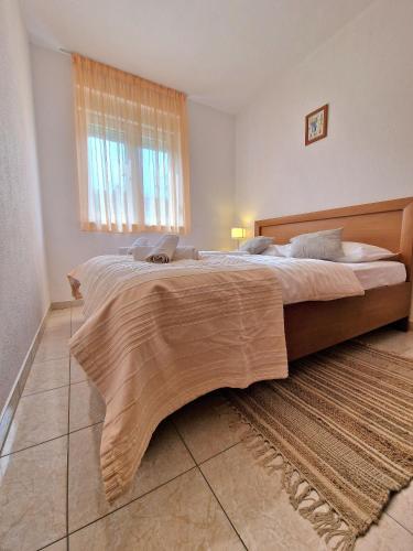 a large bed in a bedroom with a large window at Apartment Iva in Trogir