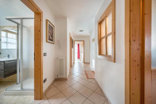 um corredor com um lavatório e uma porta de vidro em Cesa Zapin 2 em Canazei