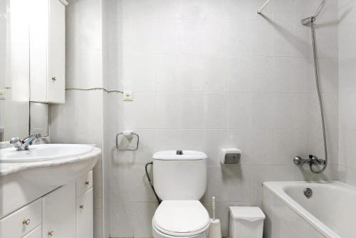 a white bathroom with a toilet and a sink at Apartamento Mercedes in Conil de la Frontera