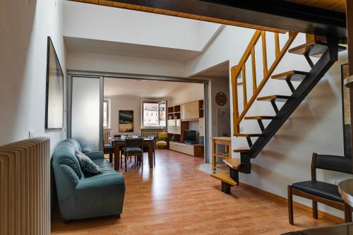 a living room with a staircase and a dining room at Appartamento Palazzo Barocci in Urbino