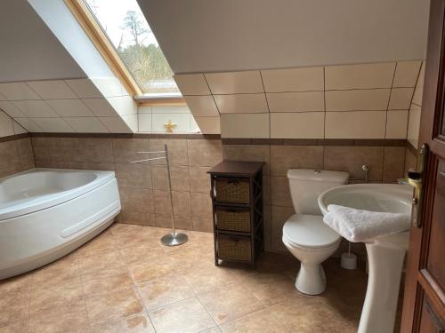 a bathroom with a tub and a toilet and a sink at Dom Wakacyjny Myśliborka in Nowe Warpno