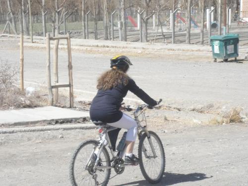 una mujer montando una bicicleta por una calle en La Quita Pena en Rodeo