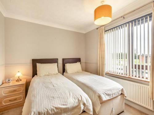 a bedroom with two beds next to a window at Blackberry - 19263 in Horsford