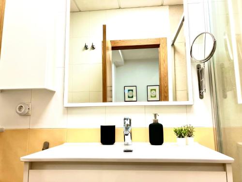 a bathroom with a sink and a mirror at Adelfa - 2 hab, AA, parking gratis, junto Hospital in Murcia