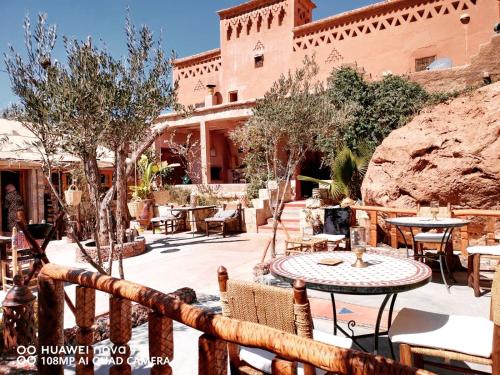 a patio with tables and chairs in front of a building at Dar Isselday in Tisselday