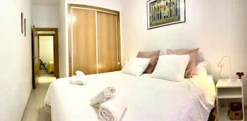 a bedroom with a white bed with white sheets at Adelfa - 2 hab, AA, parking gratis, junto Hospital in Murcia