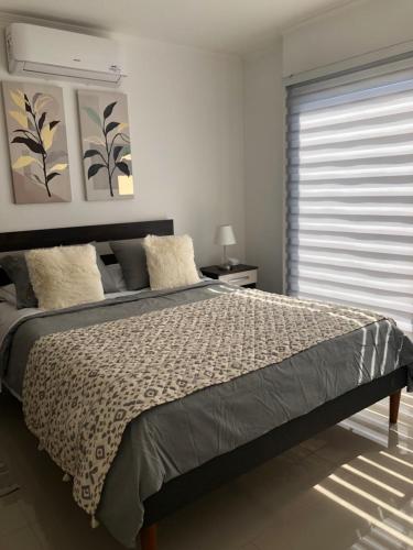 a bedroom with a large bed and a window at Departamento Los Canelos, a metros de Avenida Las Industrias- Incluye, NETFLIX DirecTV aire acondicionado, Internet in Los Ángeles