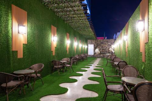 a room with a green wall with chairs and tables at Le Reve Hotel إحدى فنادق مجموعة لوريف By Le Reve Company in Taif