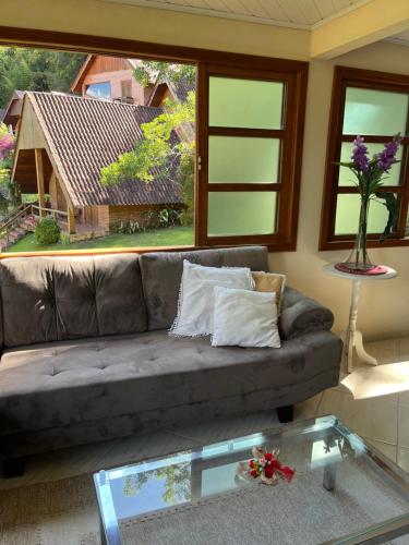 sala de estar con sofá y mesa de cristal en Chalé Vista Azul en Domingos Martins