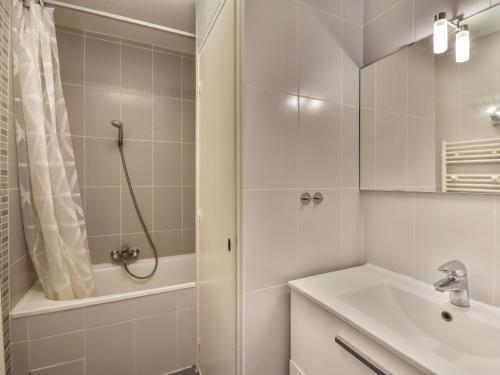 une salle de bain blanche avec une douche et un lavabo dans l'établissement Appartement T2 idéalement situé entre les télécabines Mont Chéry et Chavannes, au cœur des Gets - FR-1-685-49, aux Gets